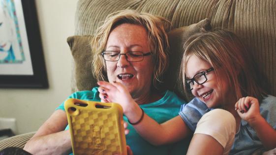 a woman and a child using a tablet